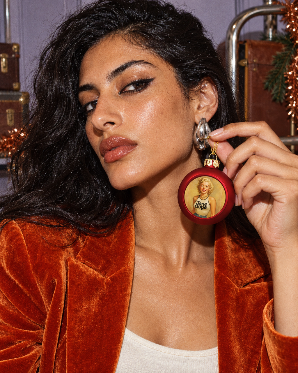 Close editorial portrait of a model holding the red Monroe Christmas Ornament