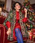 Nugs & Mistletoe Large Scarf worn open over a red party dress, showing its broad shoulder coverage and long fringed ends.
