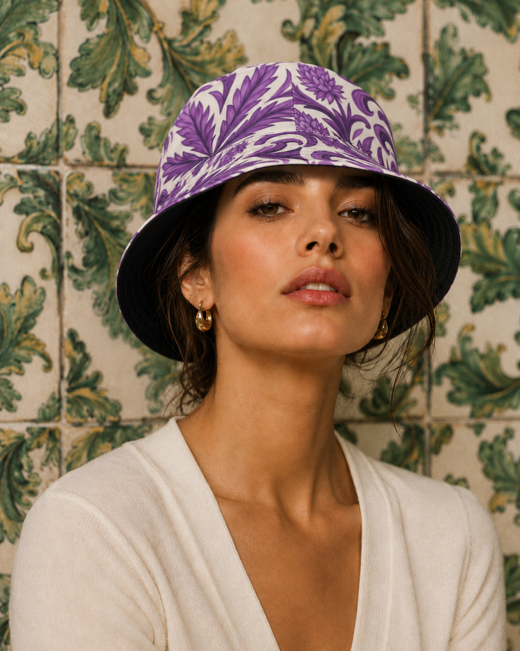 Woman wearing a purple floral-patterned bucket hat against a decorative tile wall.