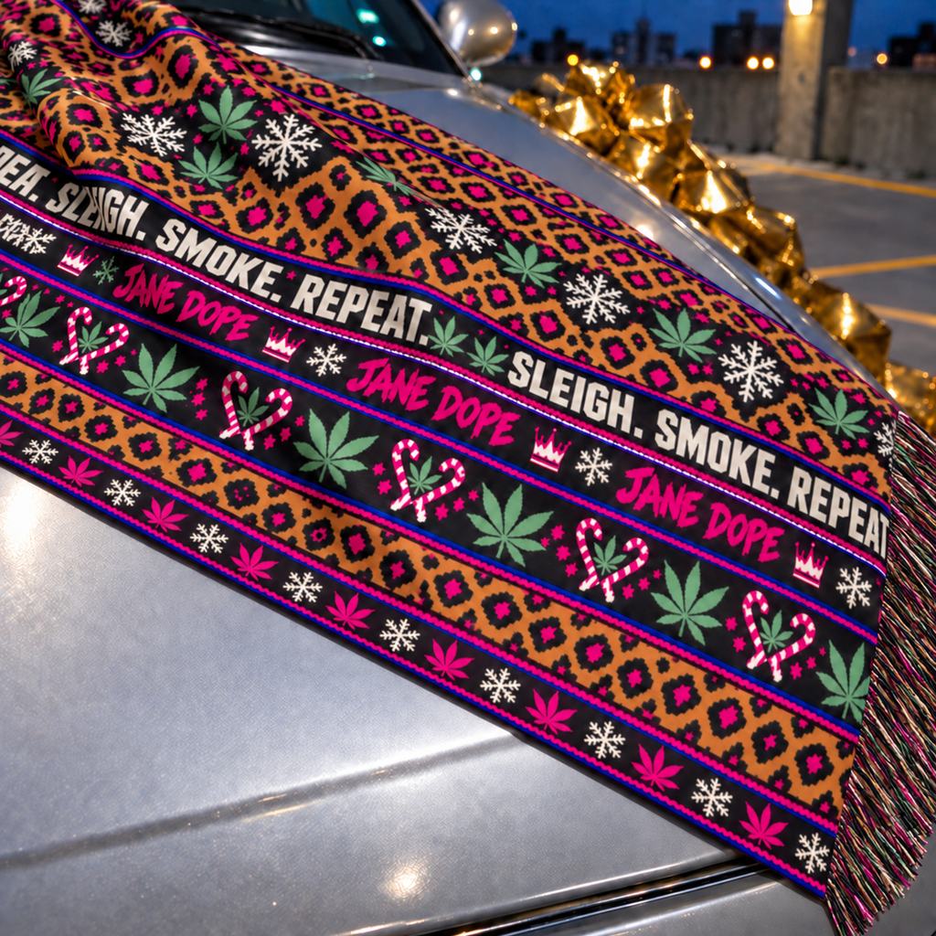 Close-up of the scarf’s imitation-cashmere fabric, printed Jane Dope lettering, holiday motifs and fine short-end fringe.
