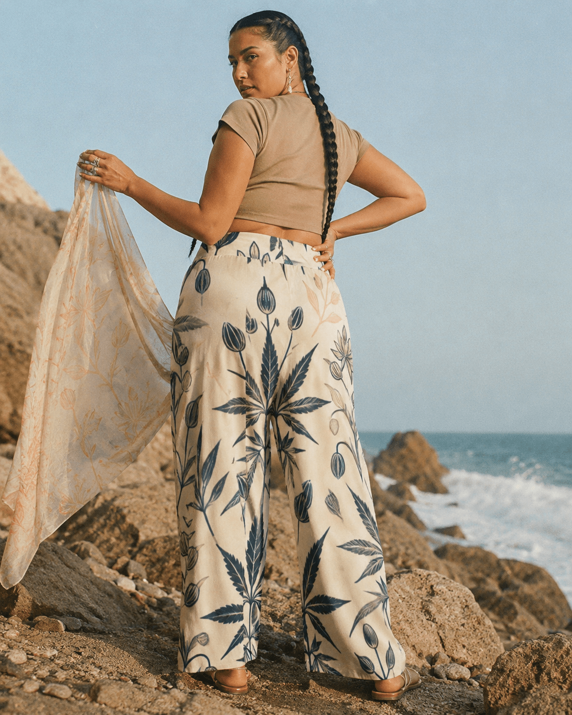 Soft sativa leaf print wide leg lounge pants, seated lifestyle shot on model