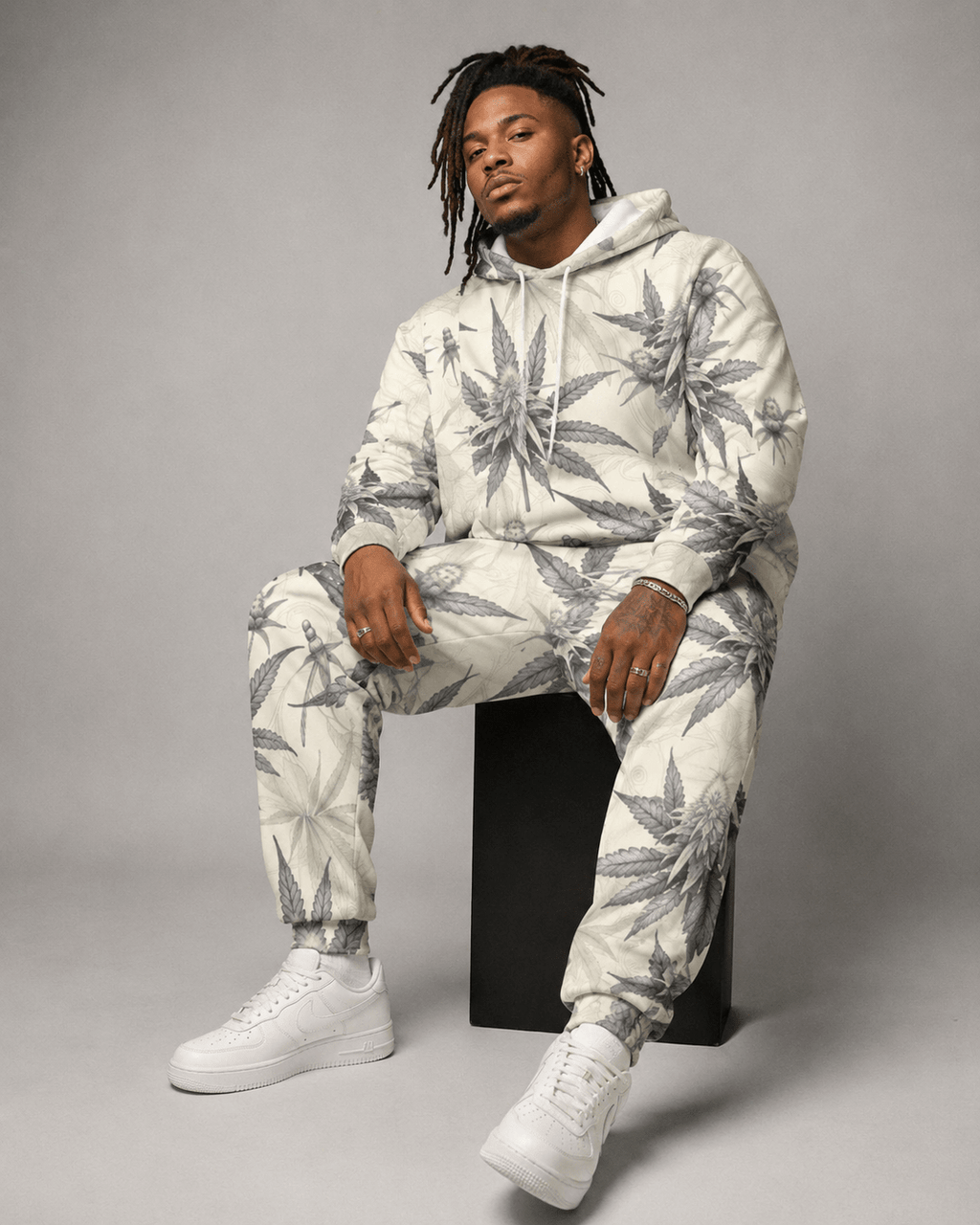 Green leaf print hoodie and sweatpants set, seated lifestyle shot on model