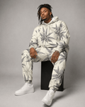 Green leaf print hoodie and sweatpants set, seated lifestyle shot on model